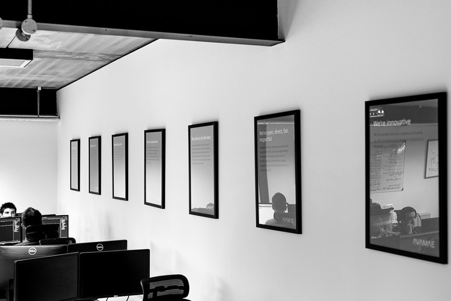 Grey photo certificates on an office wall.