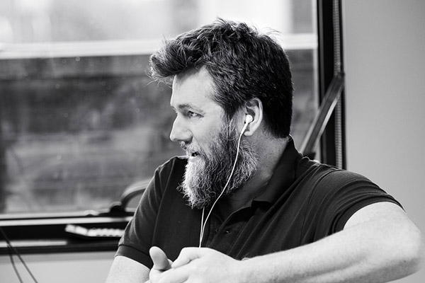 Grey photo of an employee with earphones on.