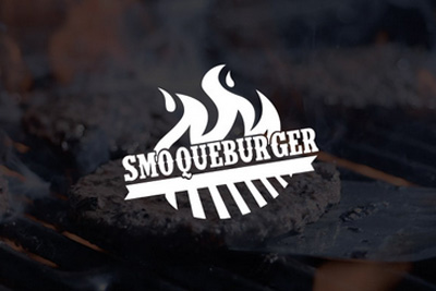 Close up of a burger patty on a grill with the words Smoque Grill written in white.